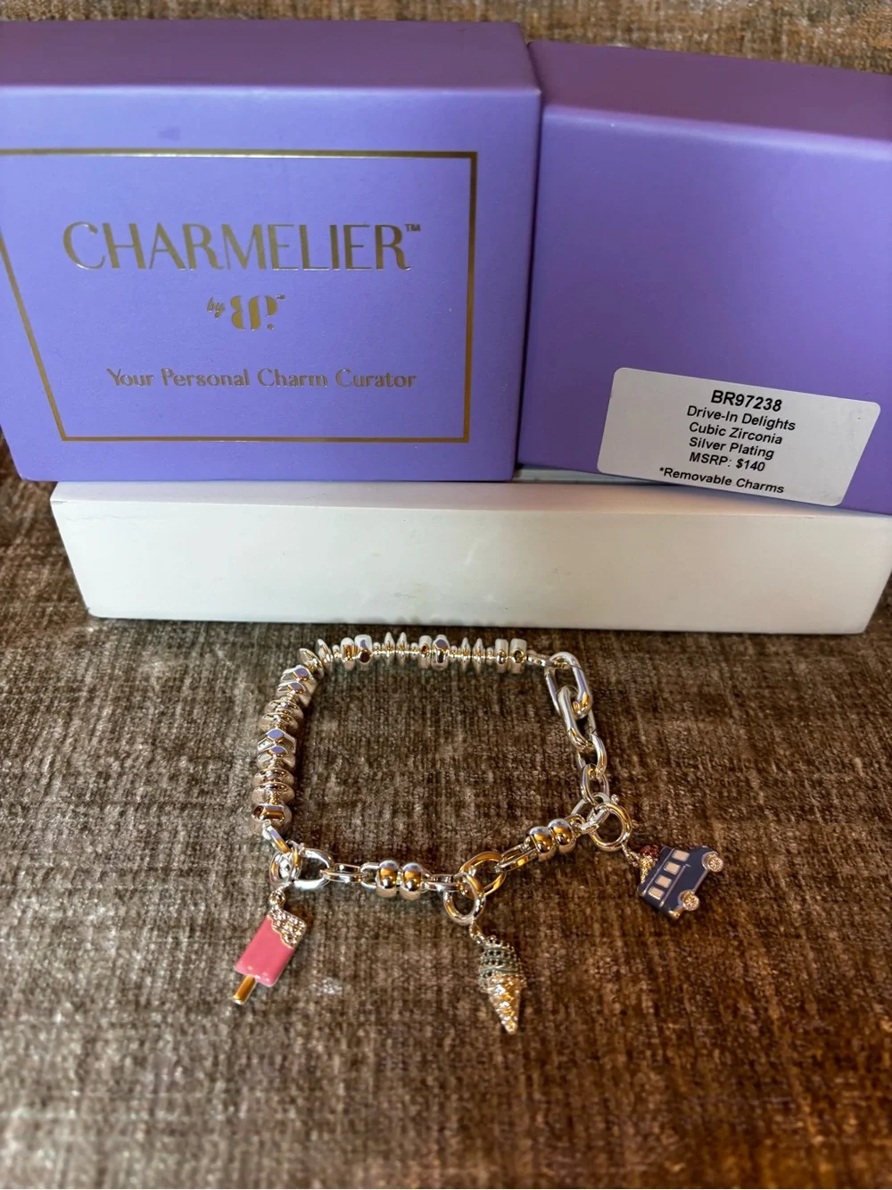 Silver plated charm bracelet with three removable charms.